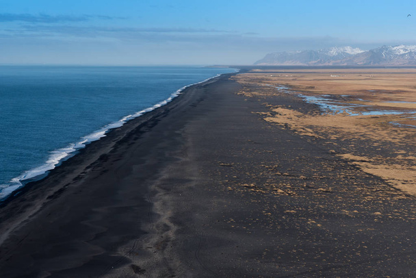 Looking west from Dyrholaey at the vast volcanic black sand beach with mountains in the background - Fotó, kép