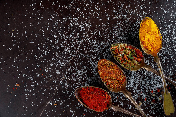 Herkullinen valikoima jauhettuja mausteen ainesosia tummalla puupohjalla
 - Valokuva, kuva