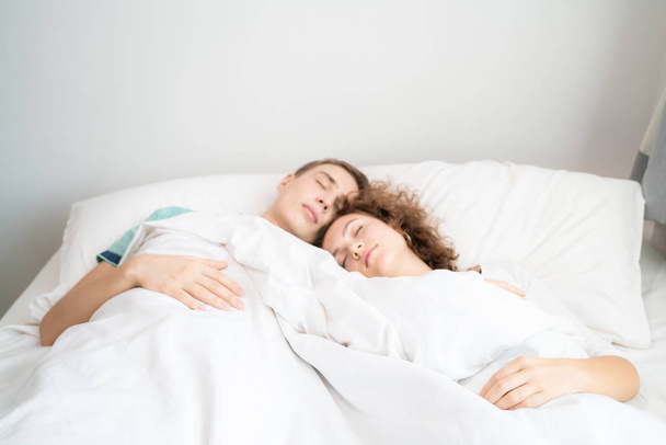 Красивий молодий чоловік і жінки люблять пара обіймається в ліжку вранці
 - Фото, зображення