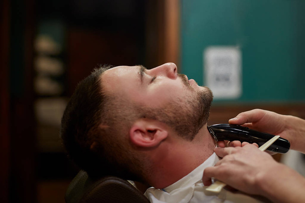 man of European Russ cuts a beard with an electric trimmer. - Photo, image