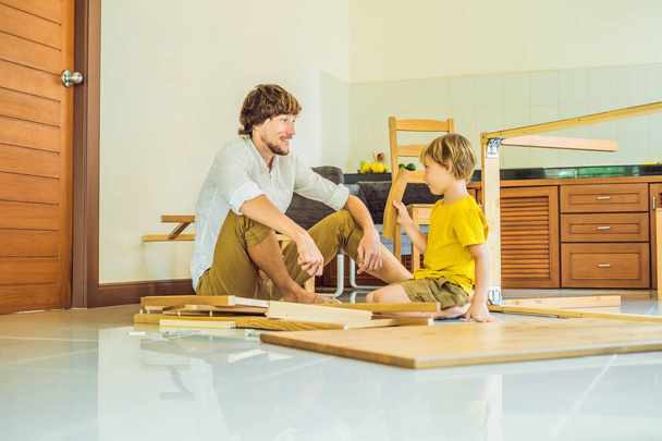 Father and son assembling furniture. Boy helping his dad at home. Happy Family concept - Fotografie, Obrázek