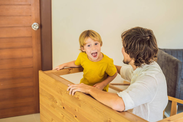 Father and son assembling furniture. Boy helping his dad at home. Happy Family concept - Foto, afbeelding