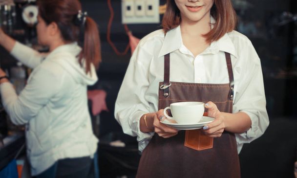 giovane barista femminile che serve caffè al cliente nel caffè
. - Foto, immagini