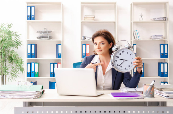 Middle-aged female employee sitting at the office   - Valokuva, kuva