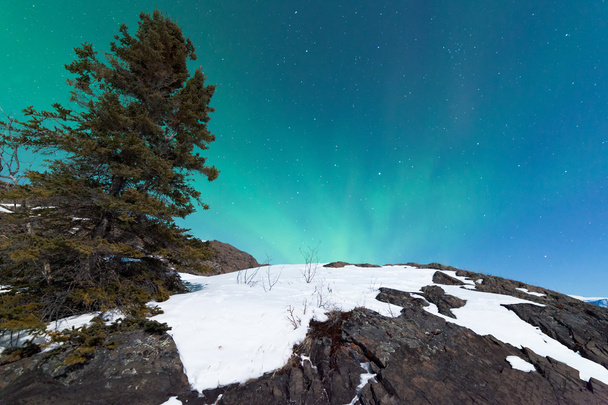 Északi fény Aurora borealis, havas sziklák felett - Fotó, kép
