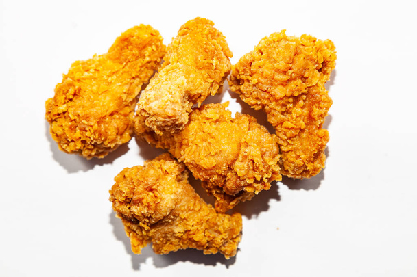 Detail smažené vynikající, chutný pět kuřecí křídla vyrobené z čerstvého masa v pikantní omáčce a obalované oblíbené jídlo v restauracích a fast food lež na bílém pozadí izolované - Fotografie, Obrázek