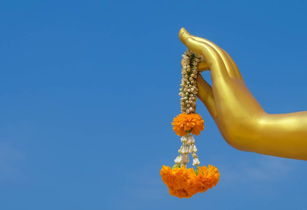 Красиві Гирлянда жасмину з боку Againt статуя Будди золото на Синє небо. Знак для поклоніння, платити поваги і зробити заслуги в Будди. - Фото, зображення