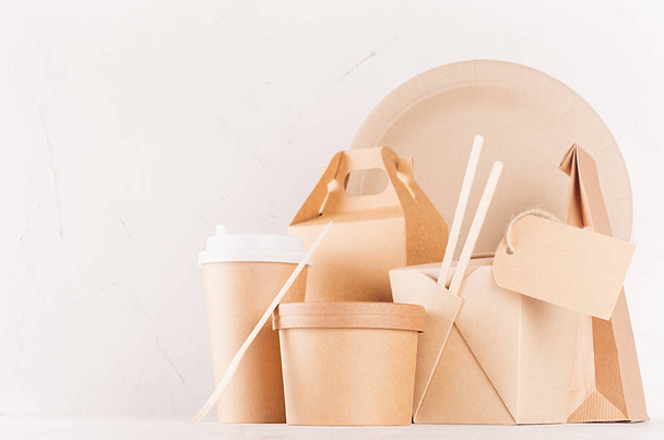 Concept design  brown paper pack for go food for restaurant, cafe, shop, advertising - different boxes, coffee cup, packet, plate, cutlery, label on white wood board. - Foto, afbeelding