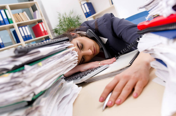 Vrouwelijke werknemer met te veel werk in het kantoor  - Foto, afbeelding