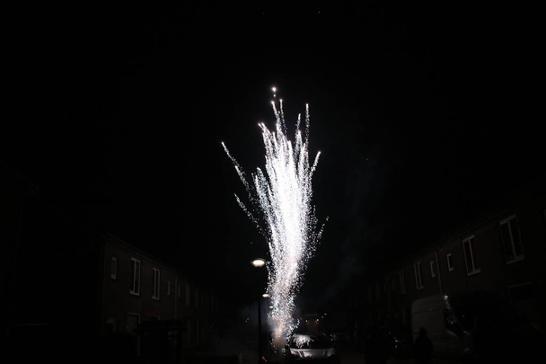 несколько цветов фейерверков взрывающихся в небе в Nieuwerkerk aan den IJssel в Нидерландах в канун нового года
. - Фото, изображение