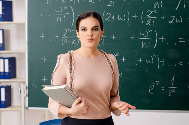 Vrouwelijke leraar staan voor schoolbord    - Foto, afbeelding