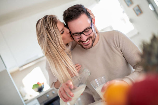Young happy couple  in modern apartment having breakfast together. - Photo, Image