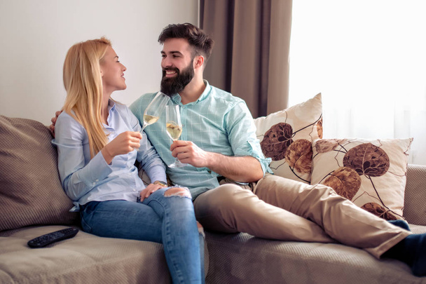 Picture of smiling loving couple at home drinking wine. - Foto, Imagem