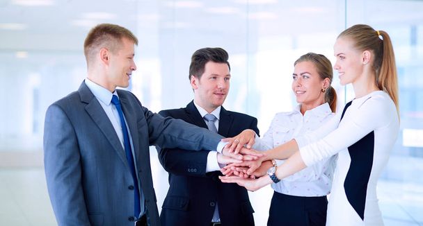 Επιχειρηματική ομάδα ενώνοντας τα χέρια μαζί στέκεται στο γραφείο. - Φωτογραφία, εικόνα