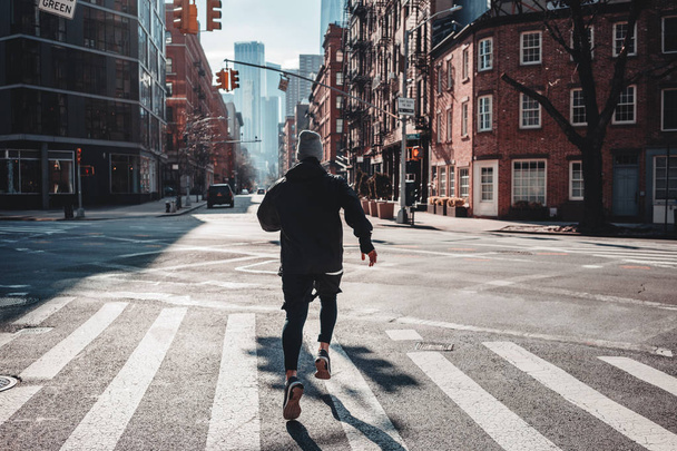 Sterke man loper opleiding en loopt door de stedelijke straten. Atleet prepearing voor marathone op nieuw uw straten. Gezonde run concept  - Foto, afbeelding