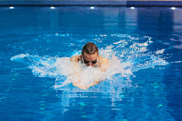 Male swimmer at the swimming pool. Underwater photo - Foto, afbeelding