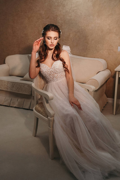 fashion  photo of beautiful  woman with dark hair in luxurious wedding dress posing in elegant interior - Zdjęcie, obraz