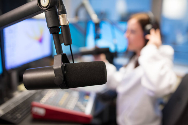 Studio microfoon in radiostation met vrouwelijke Host op achtergrond - Foto, afbeelding