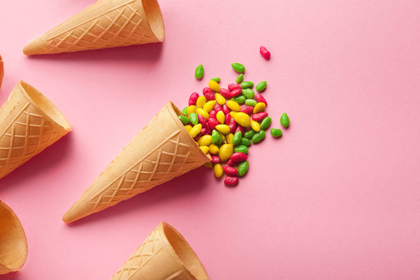 Empty ice-cream waffle cones and colorful sprinkles on pink background, - Фото, изображение