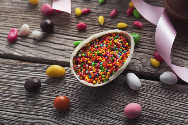Шоколадне пасхальне яйце з барвистими цукерками
 - Фото, зображення