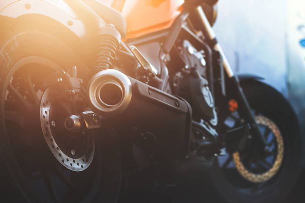 Closeup motorfiets uitlaatpijp met soft-focus en over licht in de achtergrond - Foto, afbeelding