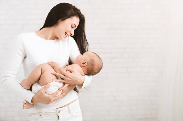 junge Mutter umarmt ihr süßes Neugeborenes - Foto, Bild