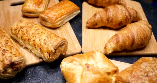 Fresh pies, croissants and cakes well-arranged on wooden boards - Footage, Video