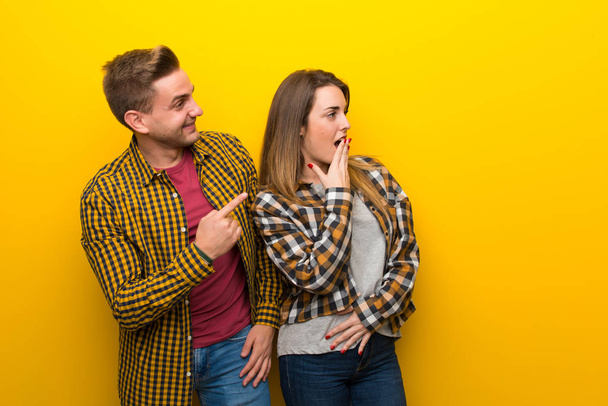 Couple in valentine day pointing finger to the side with a surprised face - Photo, Image