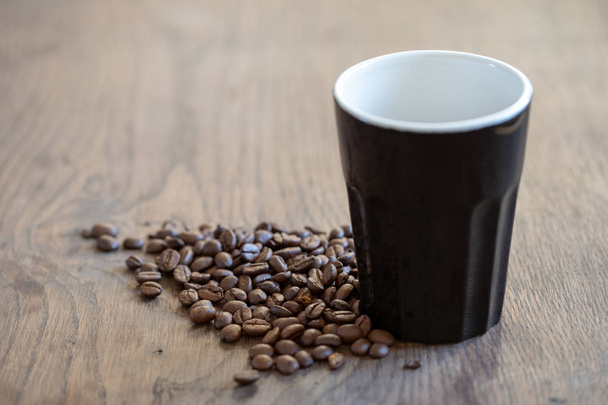чашка кави на столі в оточенні кавових зерен
 - Фото, зображення