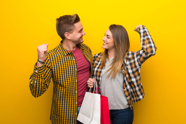 Couple in valentine day holding shopping bags in victory position - Foto, Imagem