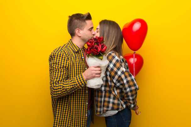 Пара в день Святого Валентина с цветами и воздушными шарами в форме сердца
 - Фото, изображение