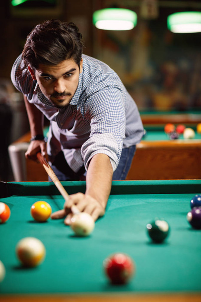 billiard game- young man playing snooker in club - 写真・画像