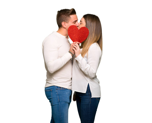 Pareja en día de San Valentín sosteniendo un símbolo del corazón y besándose
 - Foto, imagen