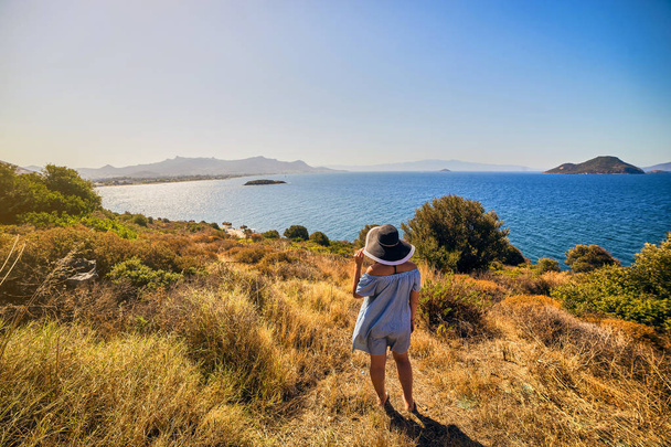 Belle femme en chapeau de plage bénéficiant d'une vue sur la mer avec un ciel bleu lors d'une journée ensoleillée à Bodrum, Turquie. Vacances en plein air Paysage marin Voyage d'été Concept
 - Photo, image