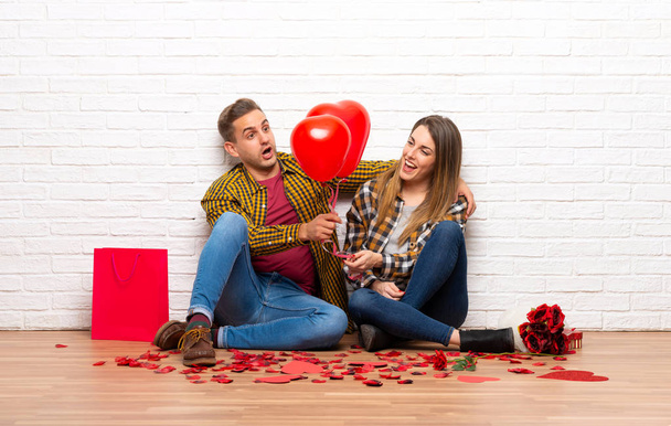 Ζευγάρι στην ημέρα του Αγίου Βαλεντίνου στο εσωτερικό με μπαλόνια με σχήμα καρδιάς - Φωτογραφία, εικόνα