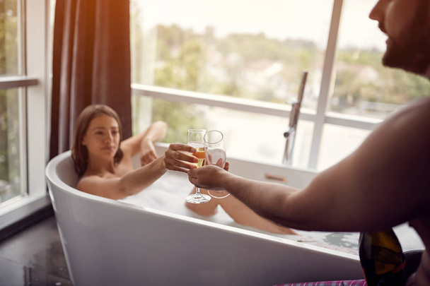 young sexy couple enjoy each other in bathroom and drink champagn - Photo, image