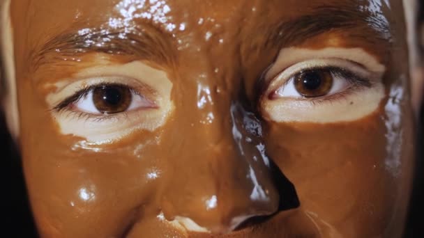 Лицо молодой девушки в шоколадной маске для лица
 - Кадры, видео