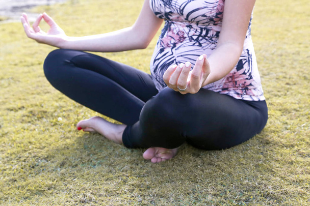 Terhes nő gyakorló jóga a parkban - Fotó, kép