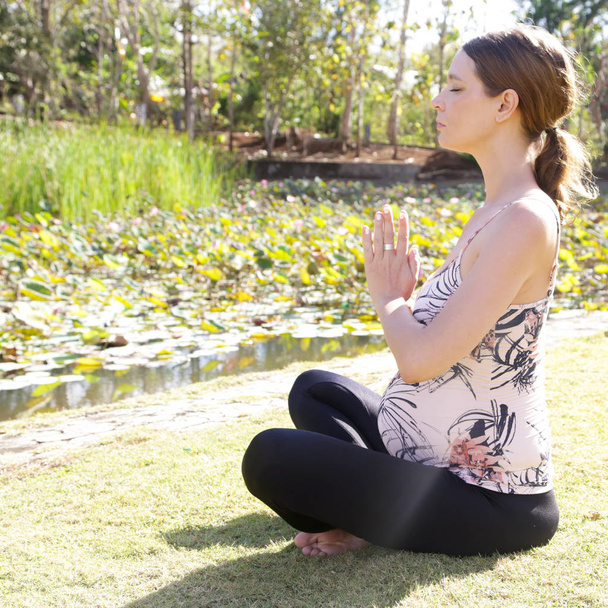 Femme enceinte pratiquant le yoga dans le parc
 - Photo, image