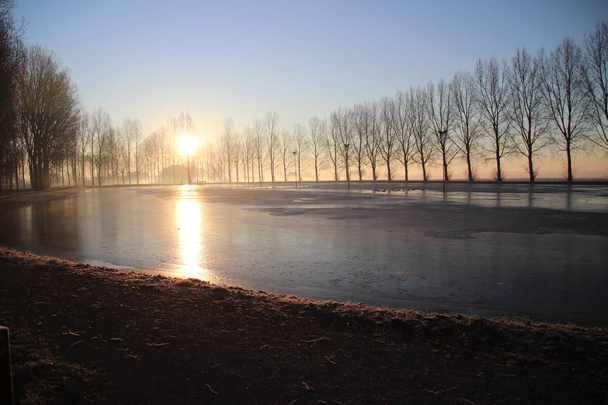 Corte de gelo não é total congelado durante o nascer do sol em Park Hitland em Nieuwerkerk aan den IJssel Países Baixos
 - Foto, Imagem