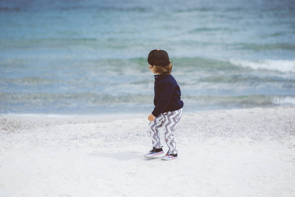 Having fun in the beach, Little boy in hat  walking on a beautiful sea  beach, beautiful summer day - Foto, Imagen