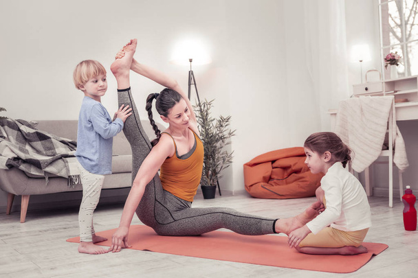 Mother doing morning exercises together with her children - Фото, изображение