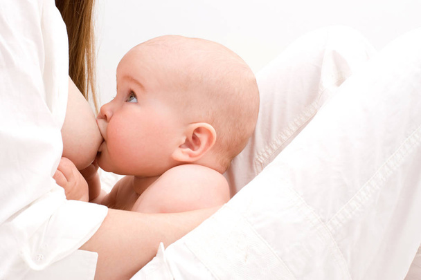 bebezinho bebendo do peito das mães enquanto olha para ela
 - Foto, Imagem