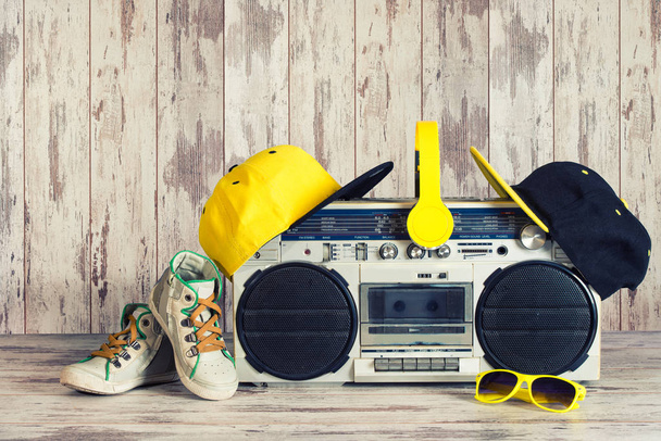 The concept of the music Hip hop style.Vintage audio player with headphones,fashionable cap, sneakers and sunglasses. - Φωτογραφία, εικόνα