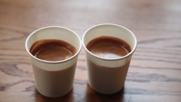 Kaksi kuppia vahvaa espressoa puupöydällä
. - Materiaali, video