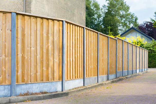 Nova cerca de madeira ao longo da estrada em área residencial
 - Foto, Imagem