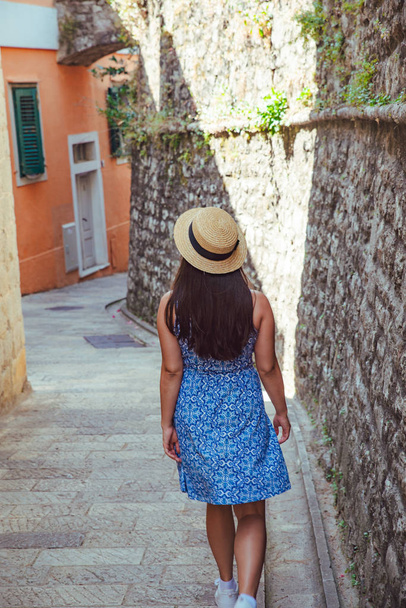 young pretty woman walking by tight european city streets. blue dress - Photo, Image