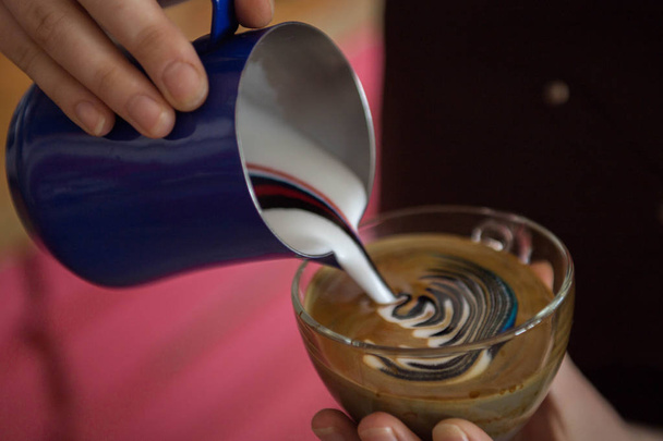 Imagen de primer plano de las manos vertiendo leche y preparando capuchino fresco, artista del café y el concepto de preparación, café de la mañana
 - Foto, Imagen