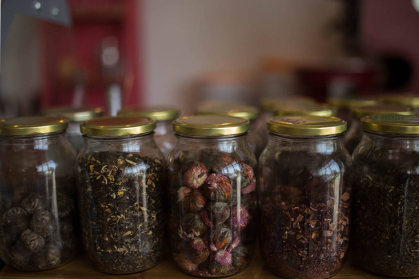 δείγματα από χαλαρά φύλλα πράσινο, κόκκινο, μαύρο και φυτικό τσάι σε γυάλινα βάζα - Φωτογραφία, εικόνα