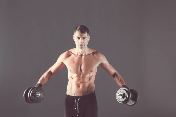 Hombre musculoso guapo haciendo ejercicio con pesas. Instructor de fitness personal. Formación personal
. - Foto, imagen